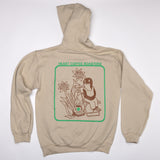Beige hoodie with a graphic design on the back on a white background. mole sitting on chair with flowers and cup of coffee