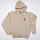 Beige hoodie with a small logo on the chest against a white background, flowers and chair graphic